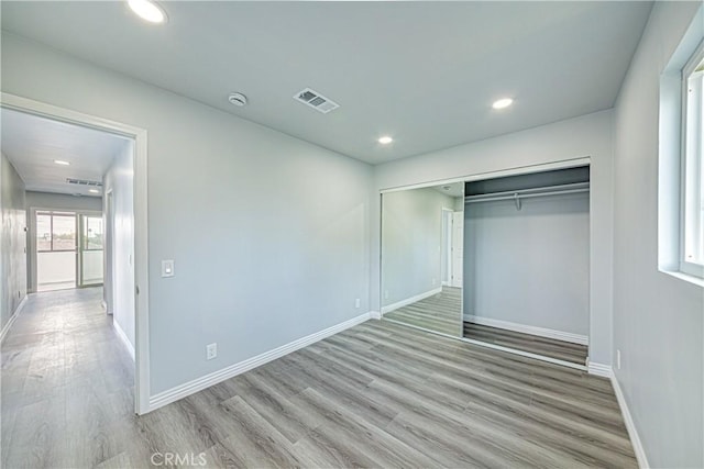 unfurnished bedroom featuring a closet and light hardwood / wood-style flooring