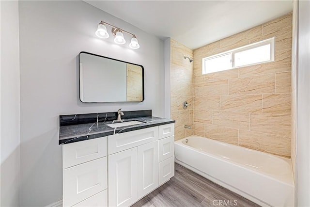 bathroom with tiled shower / bath combo, vanity, and hardwood / wood-style flooring