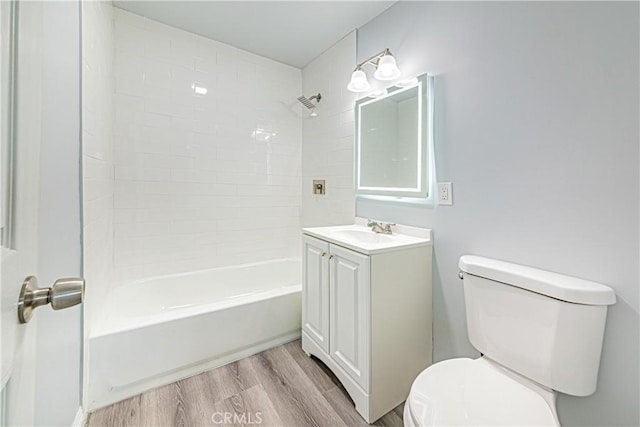 full bathroom with vanity, toilet, tiled shower / bath combo, and hardwood / wood-style floors