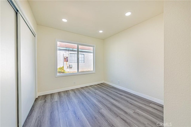 unfurnished bedroom with a closet and light hardwood / wood-style flooring