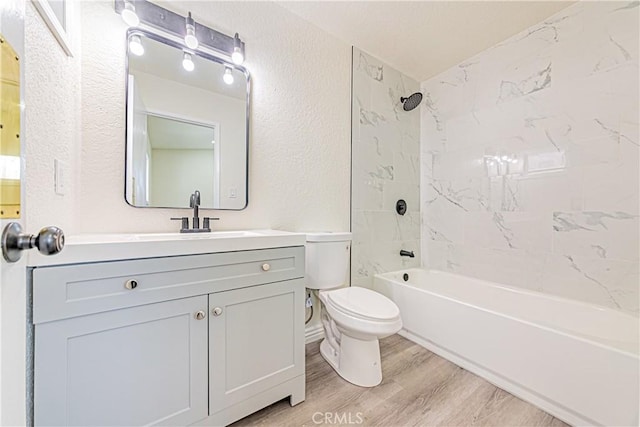 full bathroom featuring hardwood / wood-style flooring, vanity, toilet, and tiled shower / bath combo