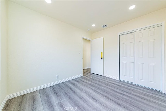 unfurnished bedroom with a closet and light wood-type flooring