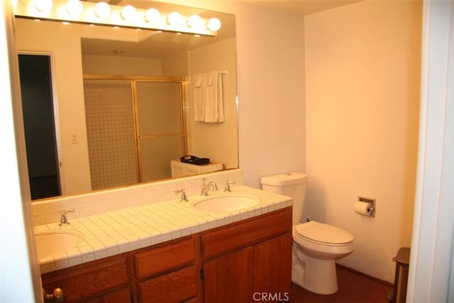 bathroom featuring vanity, toilet, and a shower with door