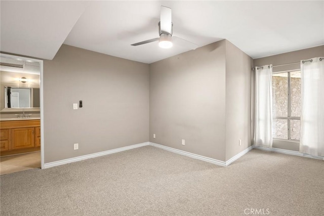 interior space featuring ceiling fan, light colored carpet, and sink