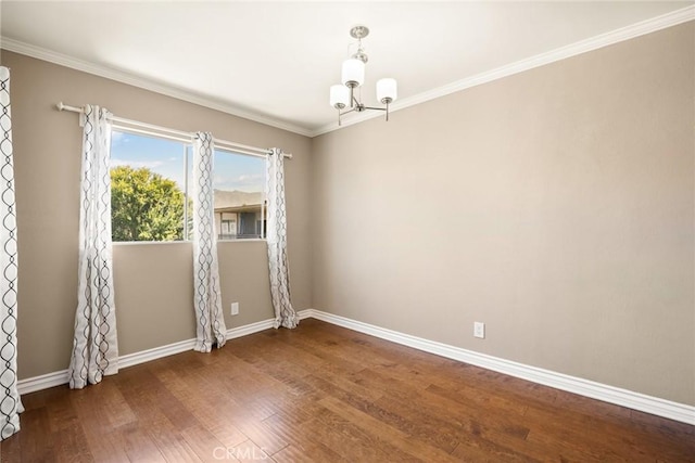 spare room with crown molding, a chandelier, and dark hardwood / wood-style flooring