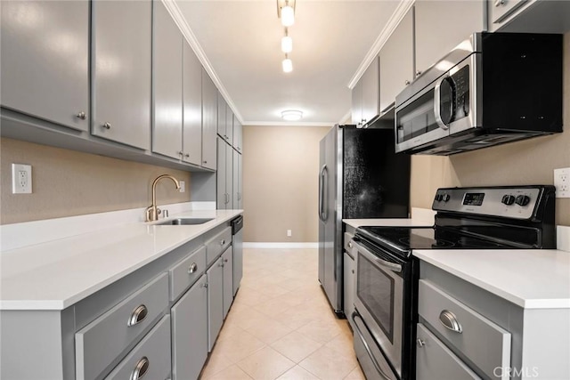 kitchen with stainless steel appliances, ornamental molding, sink, and gray cabinets