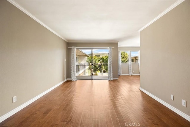 empty room with hardwood / wood-style flooring and ornamental molding