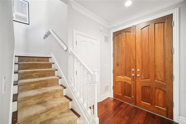 entrance foyer featuring ornamental molding and dark hardwood / wood-style floors