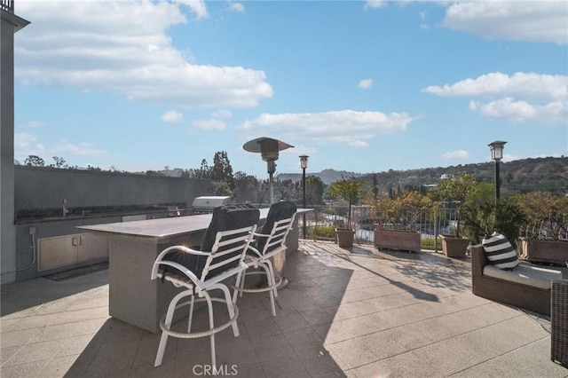 view of patio featuring exterior bar, a grill, and a mountain view