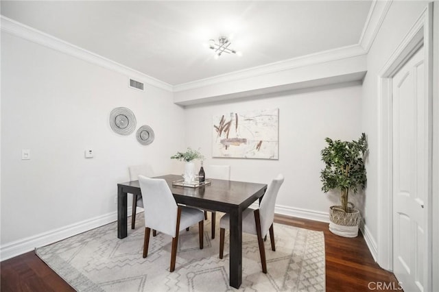 dining area with crown molding and hardwood / wood-style flooring