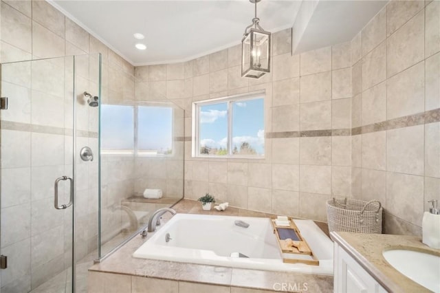 bathroom with ornamental molding, shower with separate bathtub, vanity, and tile walls