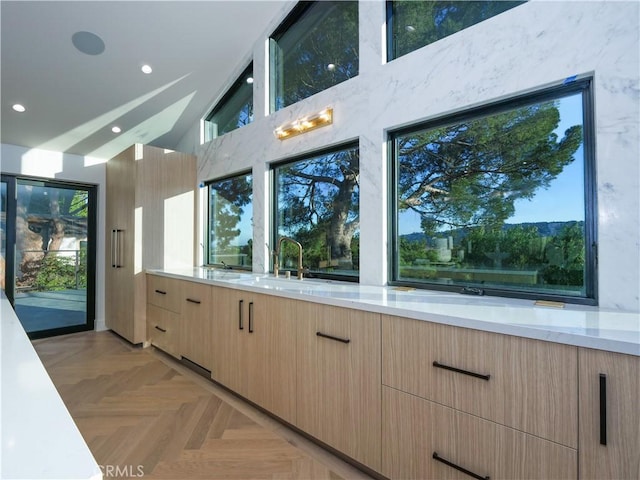 kitchen featuring light parquet flooring, plenty of natural light, sink, and light brown cabinetry