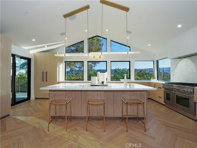 kitchen with a breakfast bar area, decorative light fixtures, double oven range, a large island, and light parquet floors