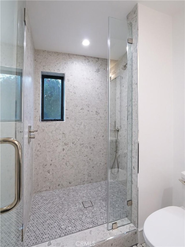 bathroom with an enclosed shower and toilet