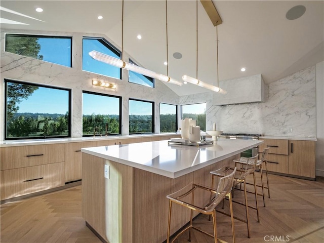 kitchen featuring a spacious island, backsplash, decorative light fixtures, and light parquet floors