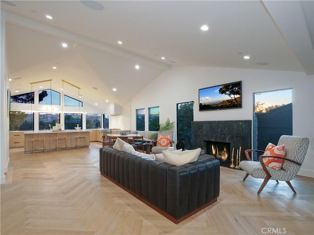 living room featuring high vaulted ceiling, a premium fireplace, and light parquet floors