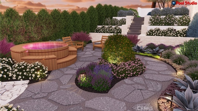 yard at dusk with an outdoor hot tub and a patio