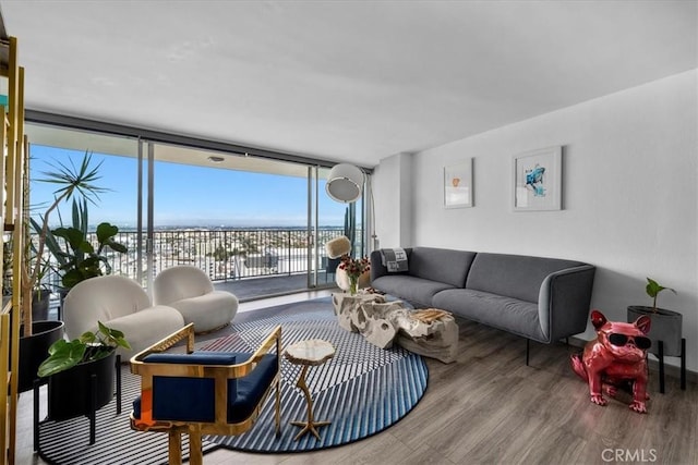 living room with wood-type flooring, a wall of windows, and a water view