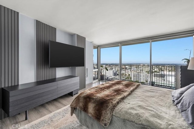 bedroom featuring light hardwood / wood-style flooring, floor to ceiling windows, and access to outside