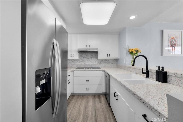 kitchen with sink, white cabinetry, stainless steel appliances, tasteful backsplash, and light stone countertops