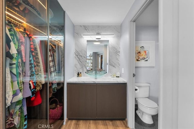 bathroom featuring hardwood / wood-style flooring, vanity, toilet, and a shower with shower door