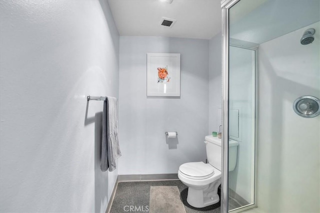 bathroom with toilet and a shower with shower door