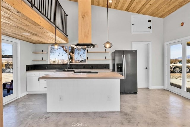 kitchen featuring white cabinetry, wood ceiling, hanging light fixtures, stainless steel fridge, and a kitchen island