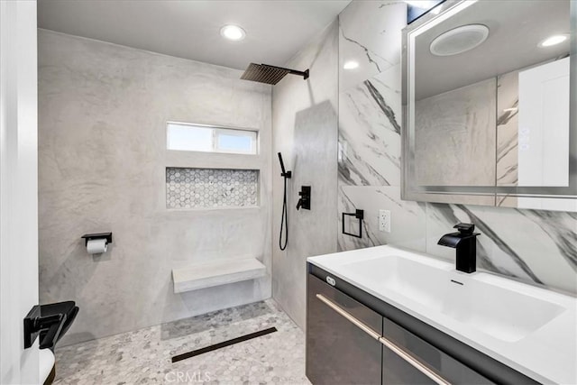 bathroom featuring vanity, tile walls, and walk in shower