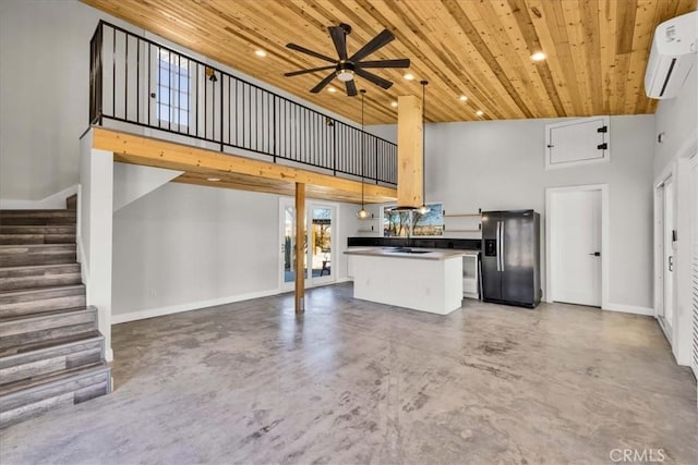 kitchen with concrete floors, wooden ceiling, stainless steel fridge, a wall unit AC, and pendant lighting