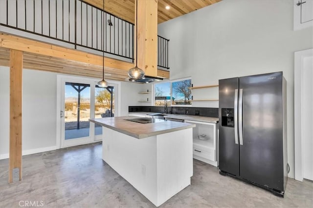 kitchen featuring white cabinetry, a towering ceiling, stainless steel refrigerator with ice dispenser, black electric stovetop, and decorative light fixtures