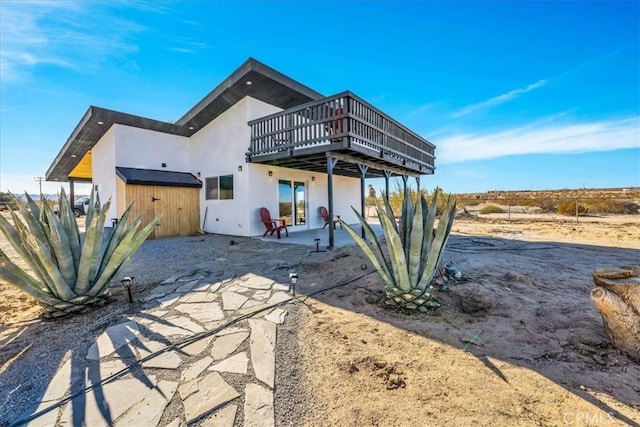 back of property featuring a deck and a patio