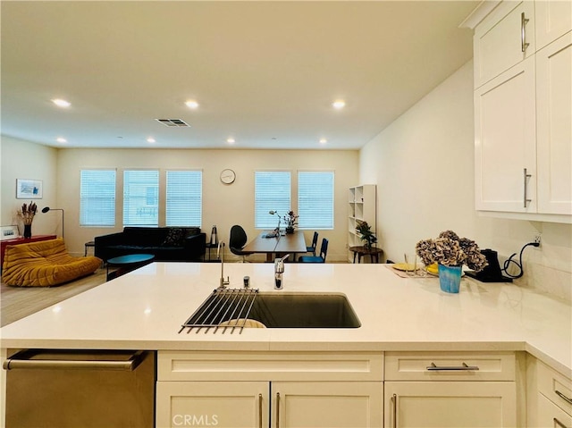 kitchen with a healthy amount of sunlight, sink, and white cabinets