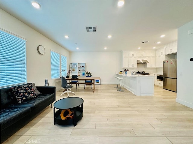 living room featuring recessed lighting, visible vents, and light wood finished floors