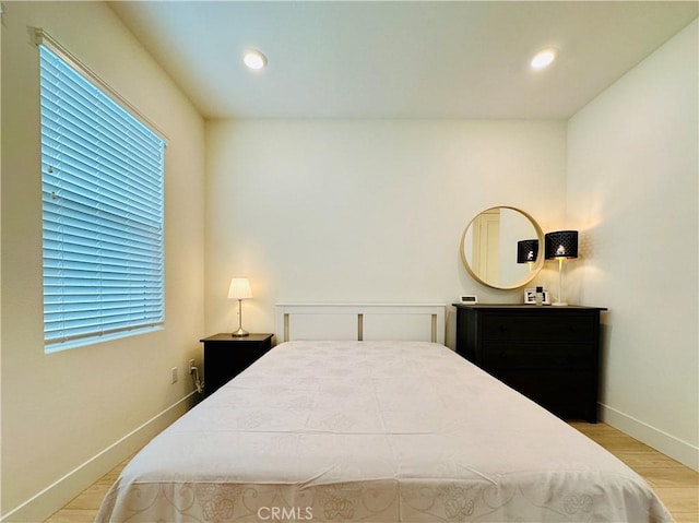 bedroom with multiple windows and light wood-type flooring