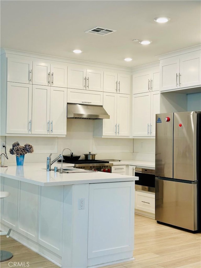 kitchen with white cabinetry, appliances with stainless steel finishes, sink, and light wood-type flooring