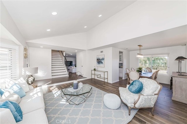 living room featuring dark wood-type flooring and high vaulted ceiling