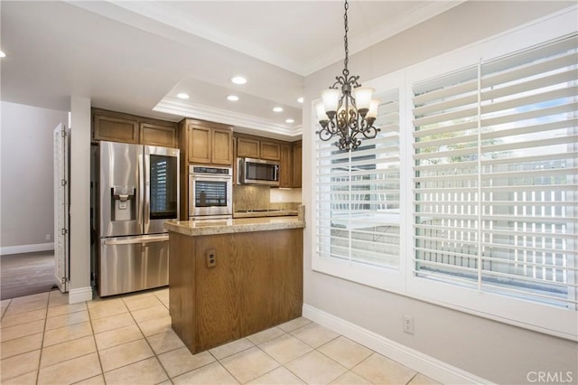 kitchen featuring pendant lighting, plenty of natural light, a raised ceiling, and appliances with stainless steel finishes