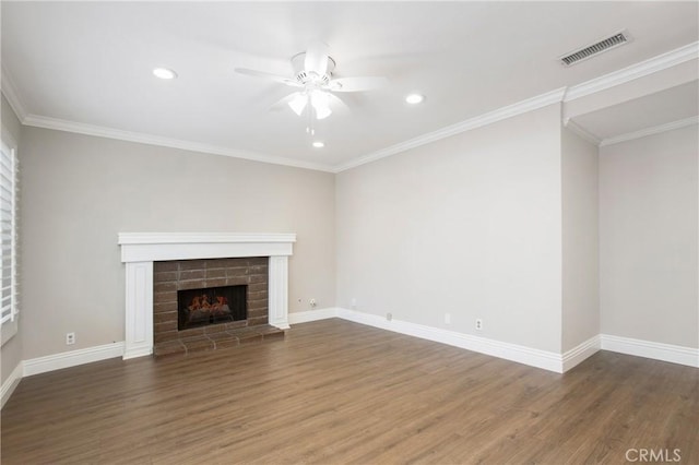 unfurnished living room featuring ornamental molding, a brick fireplace, ceiling fan, and dark hardwood / wood-style flooring