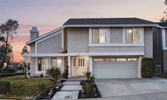 view of front of home featuring a garage and a lawn