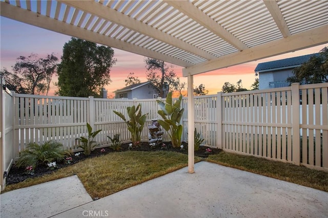 patio terrace at dusk with a yard and a pergola