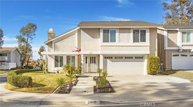 view of front of property featuring a garage and a front lawn