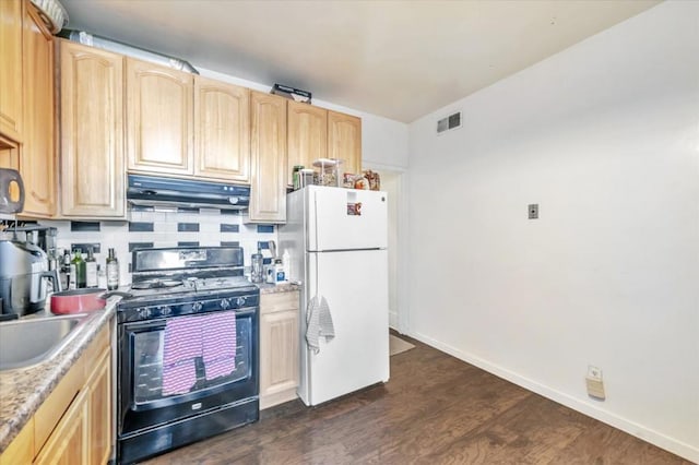 kitchen with white refrigerator, dark hardwood / wood-style floors, black gas range, and light brown cabinets