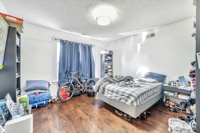 bedroom featuring hardwood / wood-style flooring and a textured ceiling