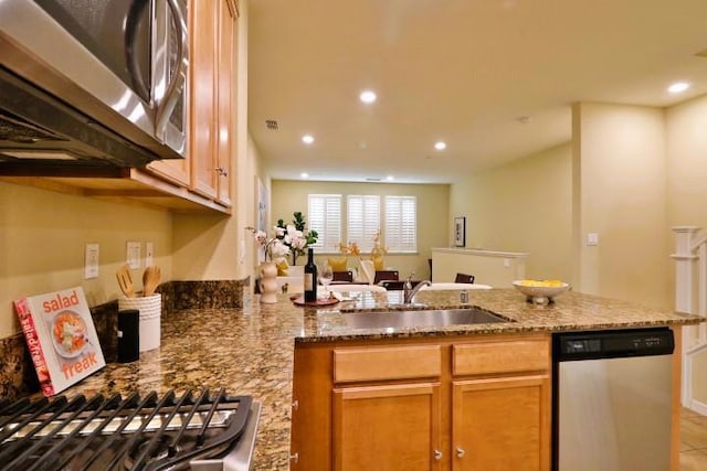 kitchen featuring sink, stainless steel appliances, kitchen peninsula, and light stone countertops