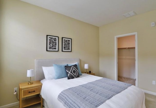 bedroom with a walk in closet and carpet flooring