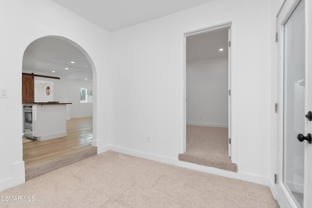 carpeted spare room with a barn door