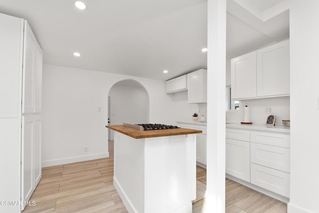 kitchen with white cabinets, wooden counters, light wood-type flooring, and gas cooktop