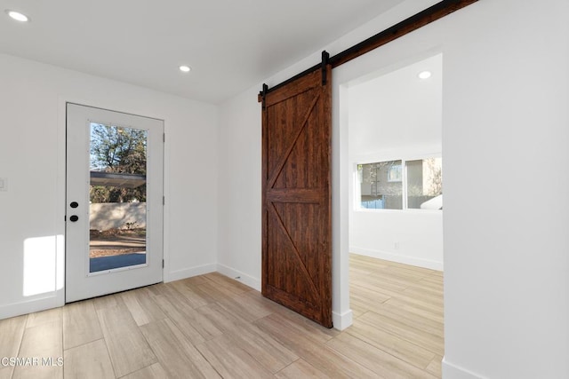 interior space with a barn door and light hardwood / wood-style flooring