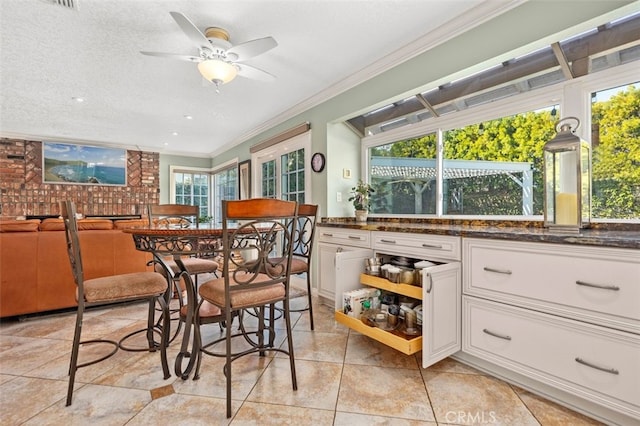 dining room featuring ceiling fan, ornamental molding, and a textured ceiling