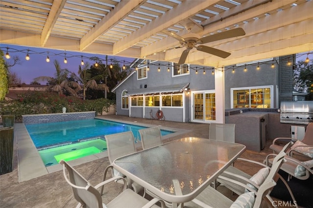 view of swimming pool featuring a patio, an outdoor kitchen, area for grilling, ceiling fan, and a pergola